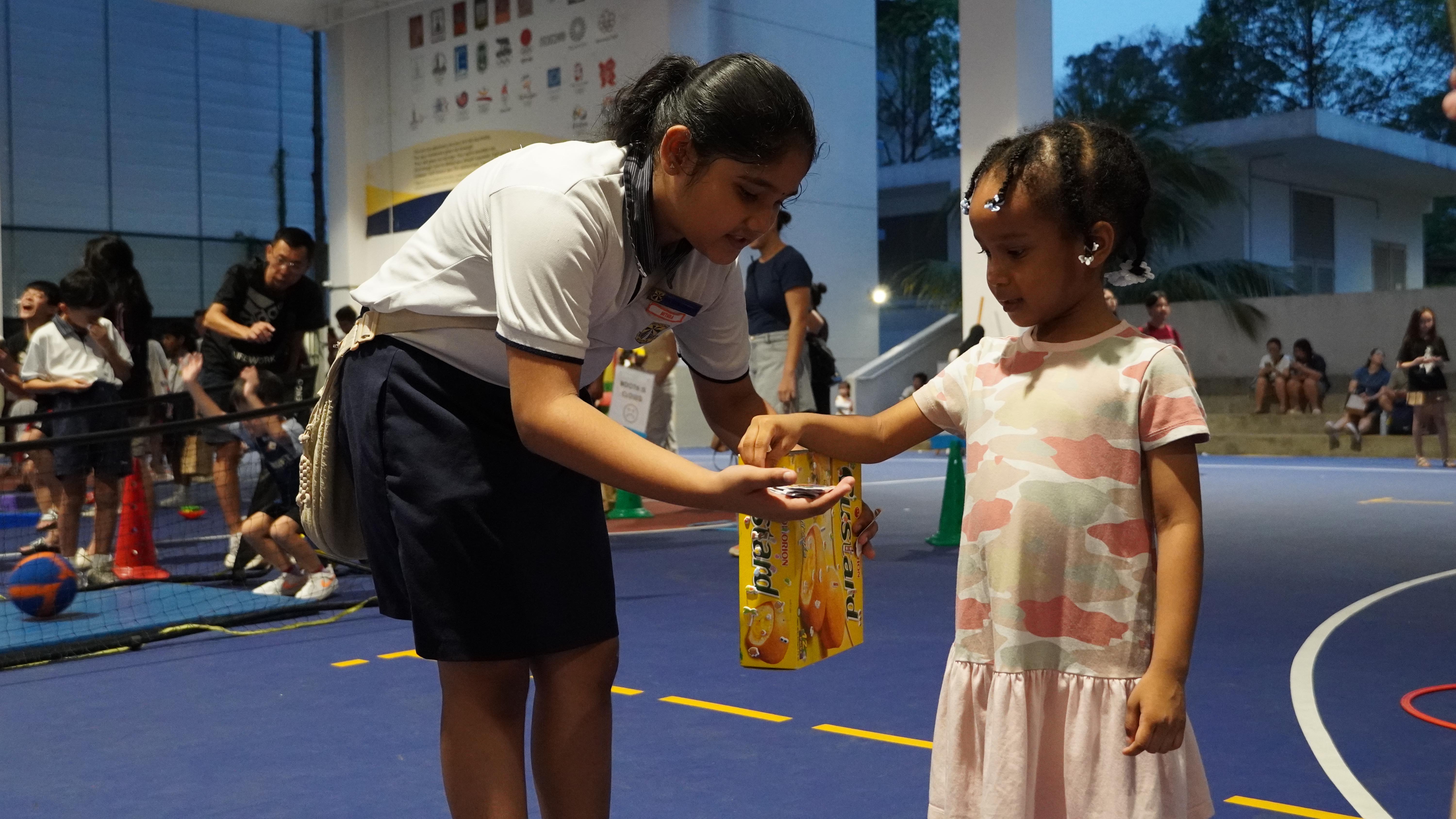 Our student giving out stickers as reward after participants finished playing the game.